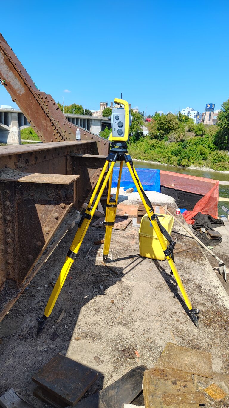 Robotic total station on a steel truss bridge deck during construction layout in Brantford, Ontario